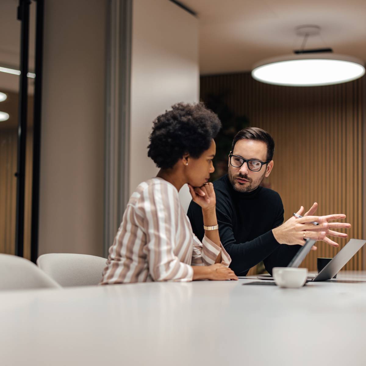 会議室で話し合う男女