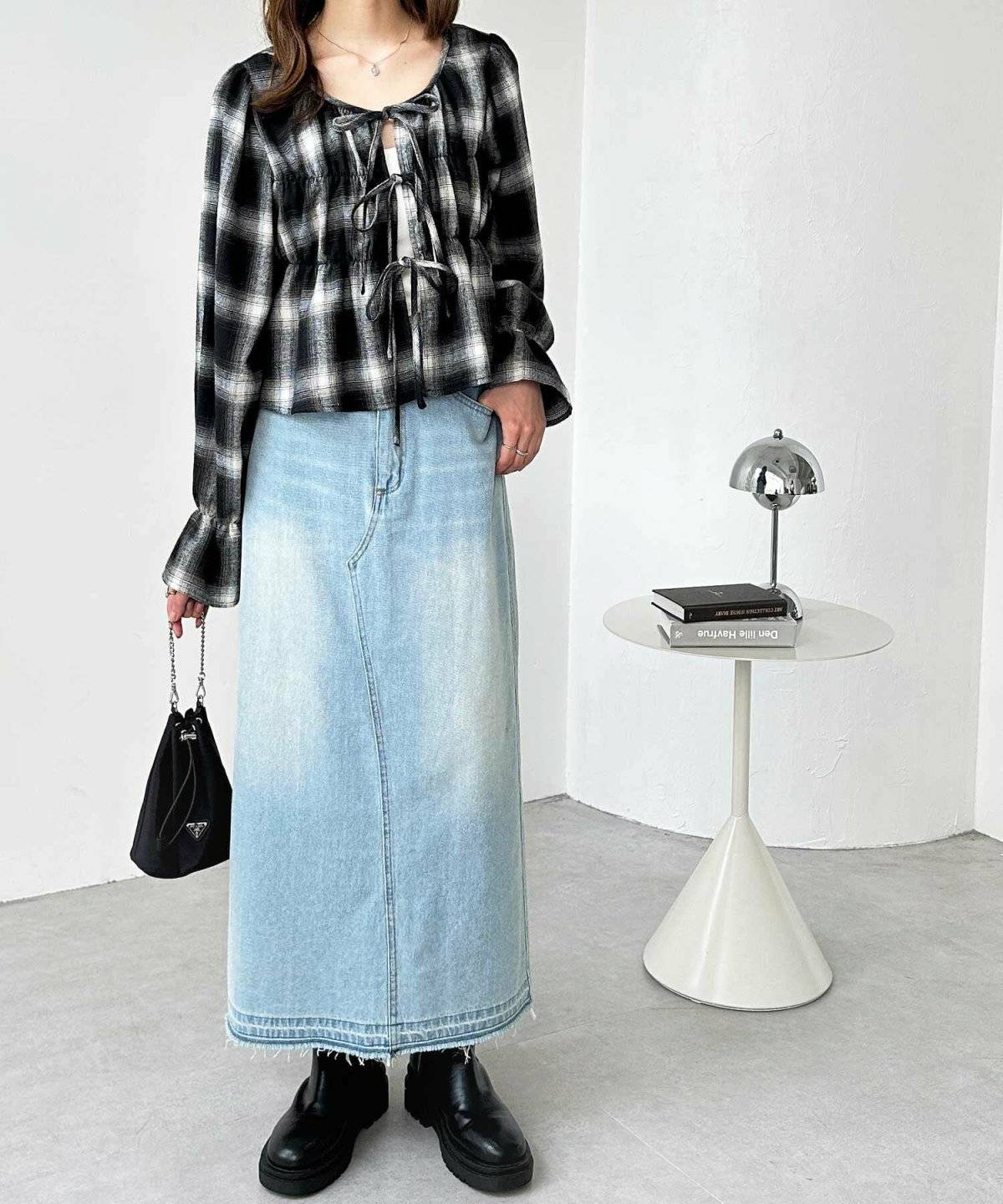 チェック柄シャツにデニムスカートを合わせた女性