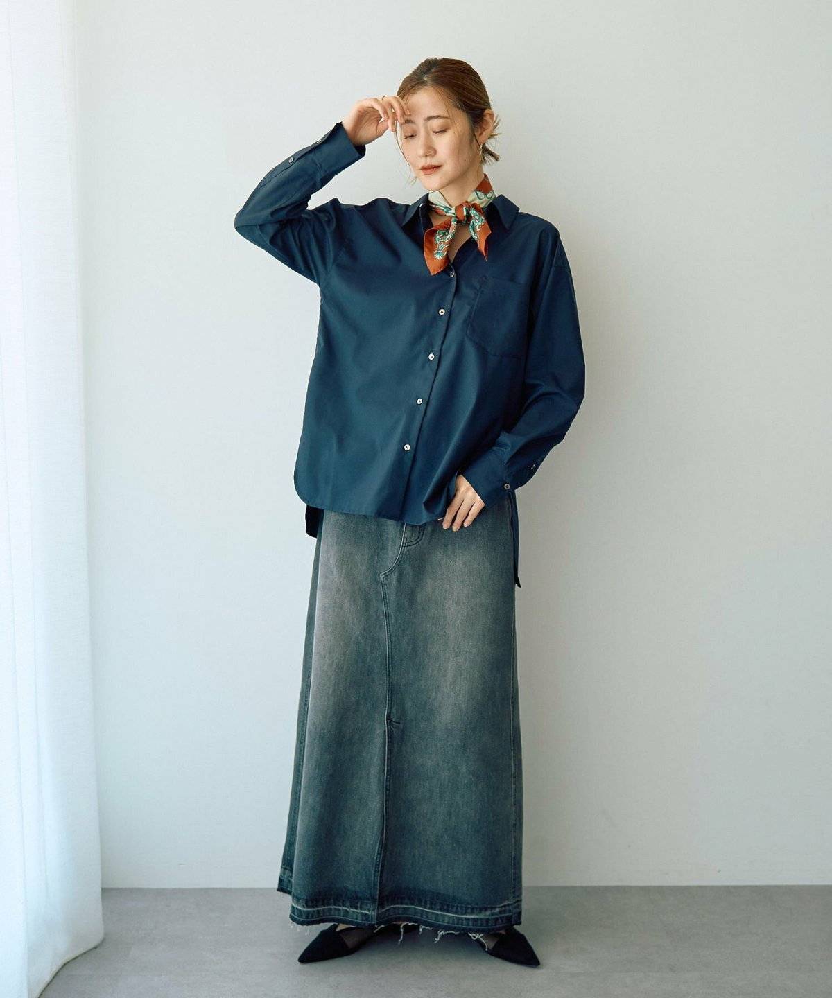 ネイビーシャツにデニムスカートを合わせた女性