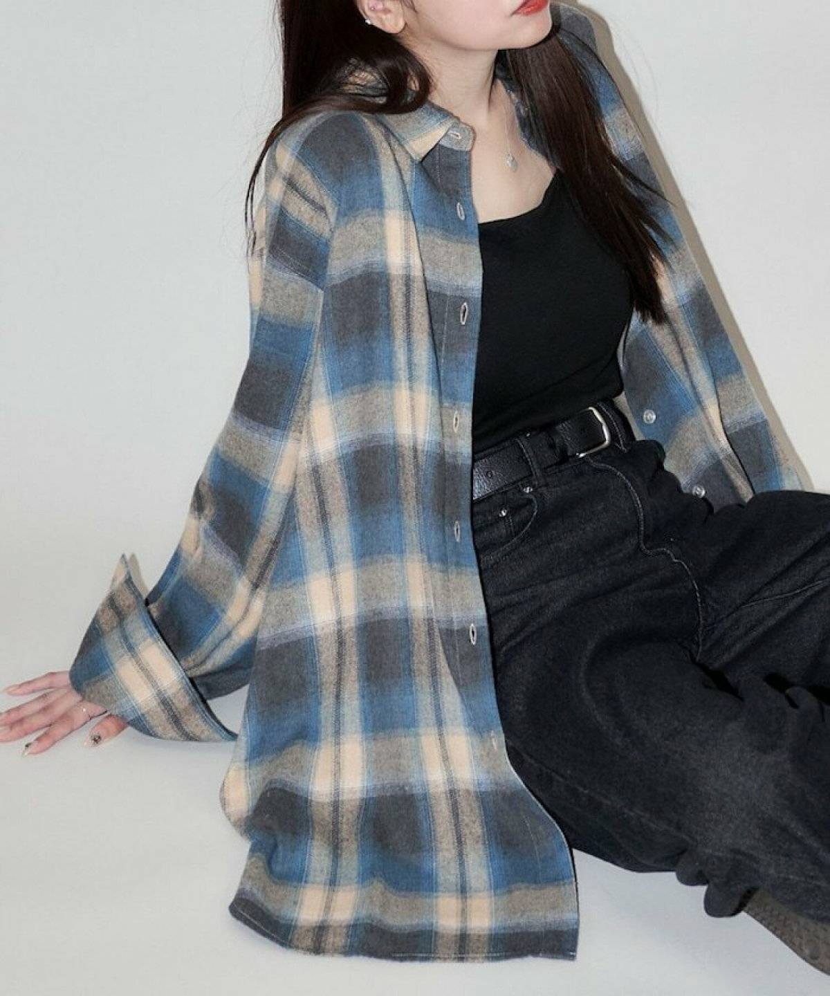 チェック柄シャツに黒デニムを合わせた女性