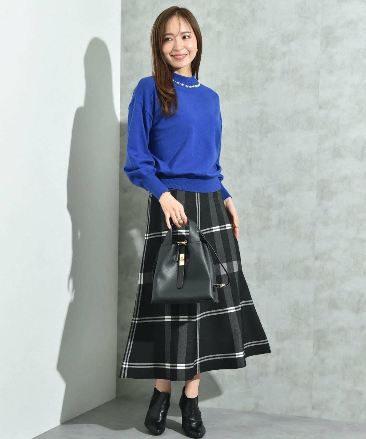ニットにチェック柄スカートを合わせた女性