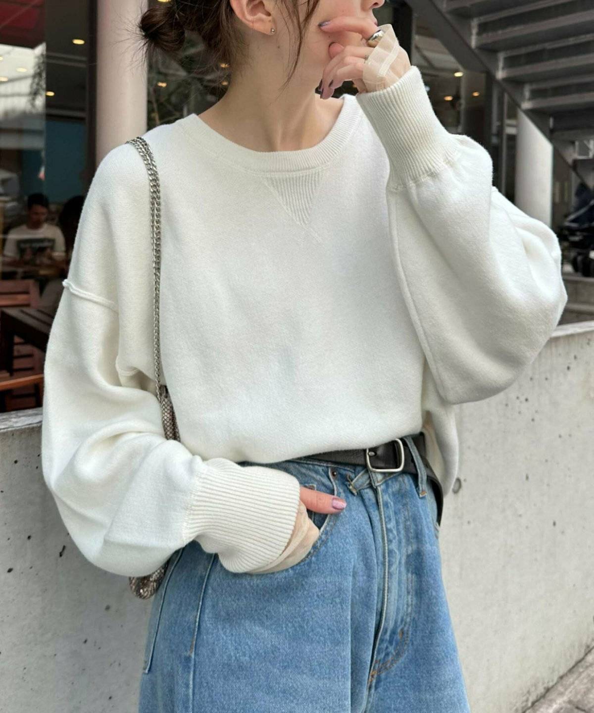 白ニットにデニムを合わせた女性