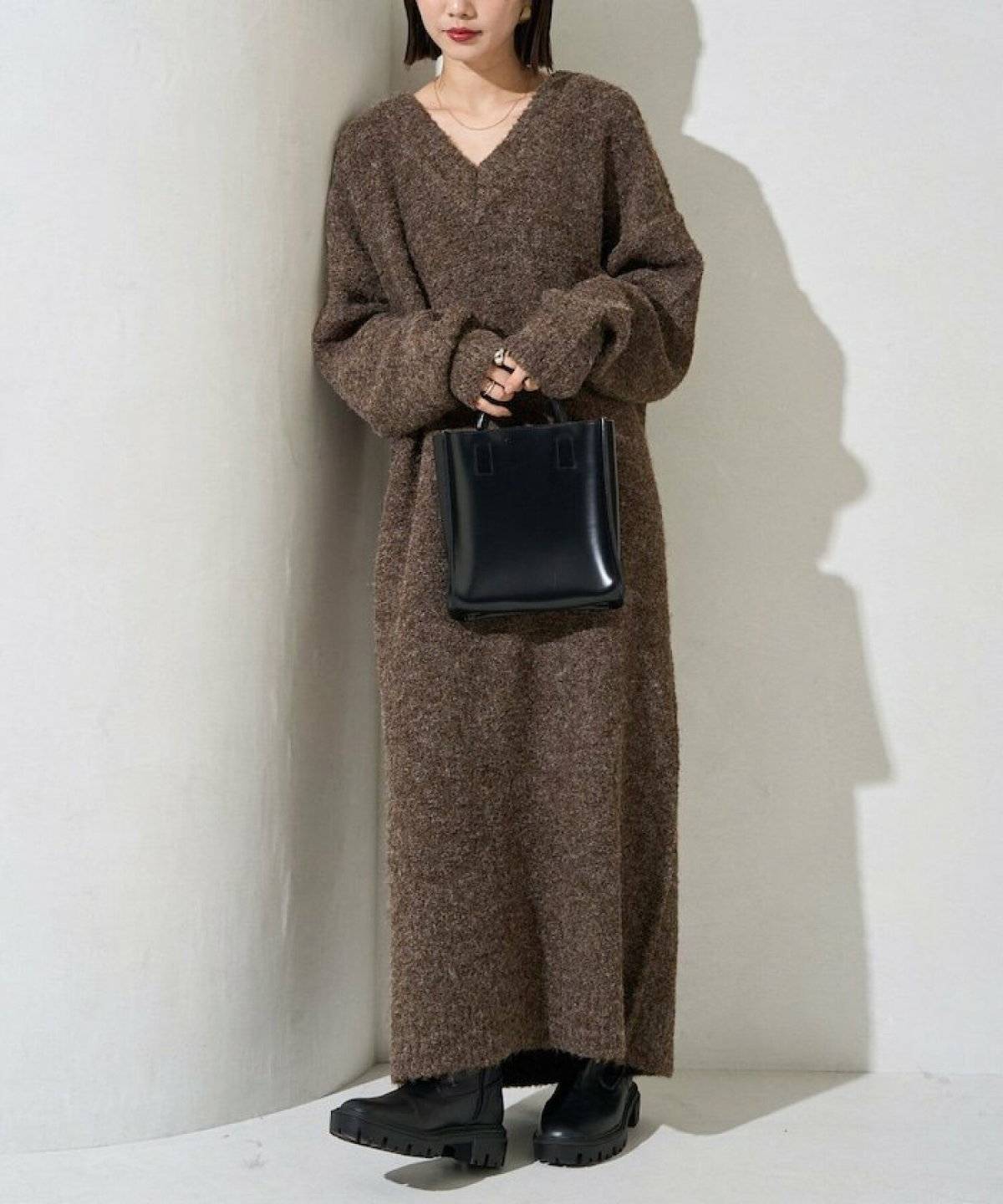 ブラウンのニットワンピースを着た女性