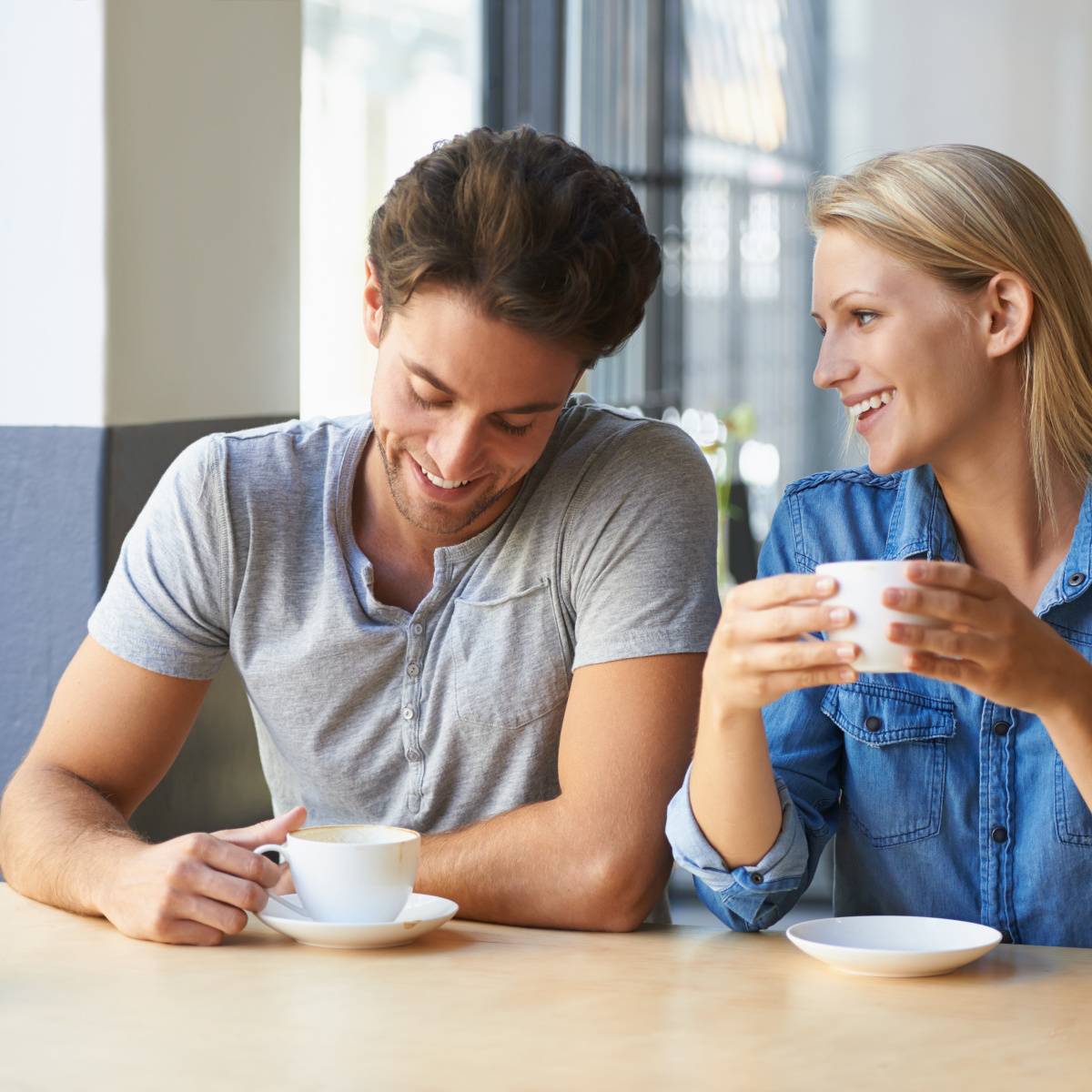 カフェでコーヒーを飲みながら話す男女