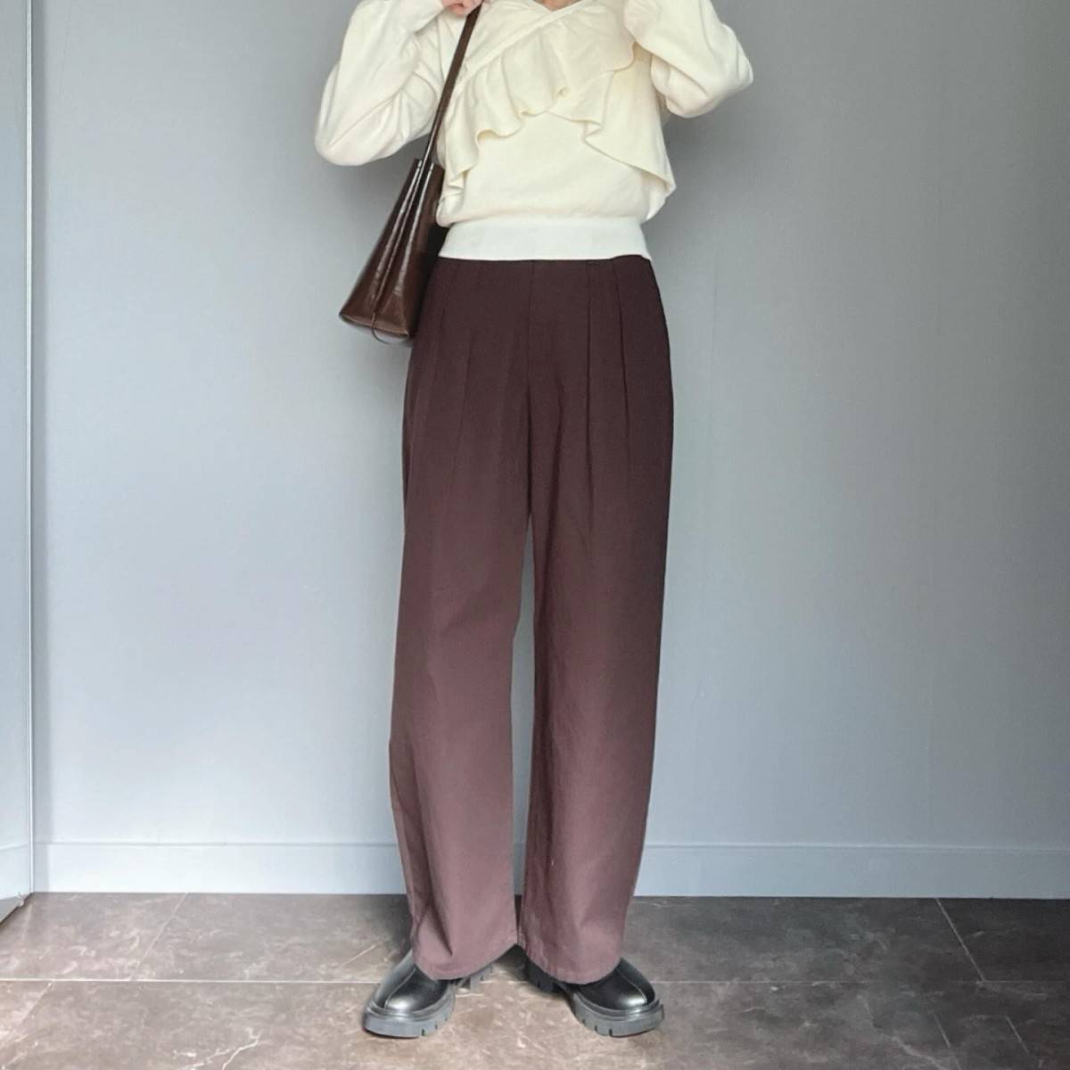 白ニットに黒パンツを合わせた女性