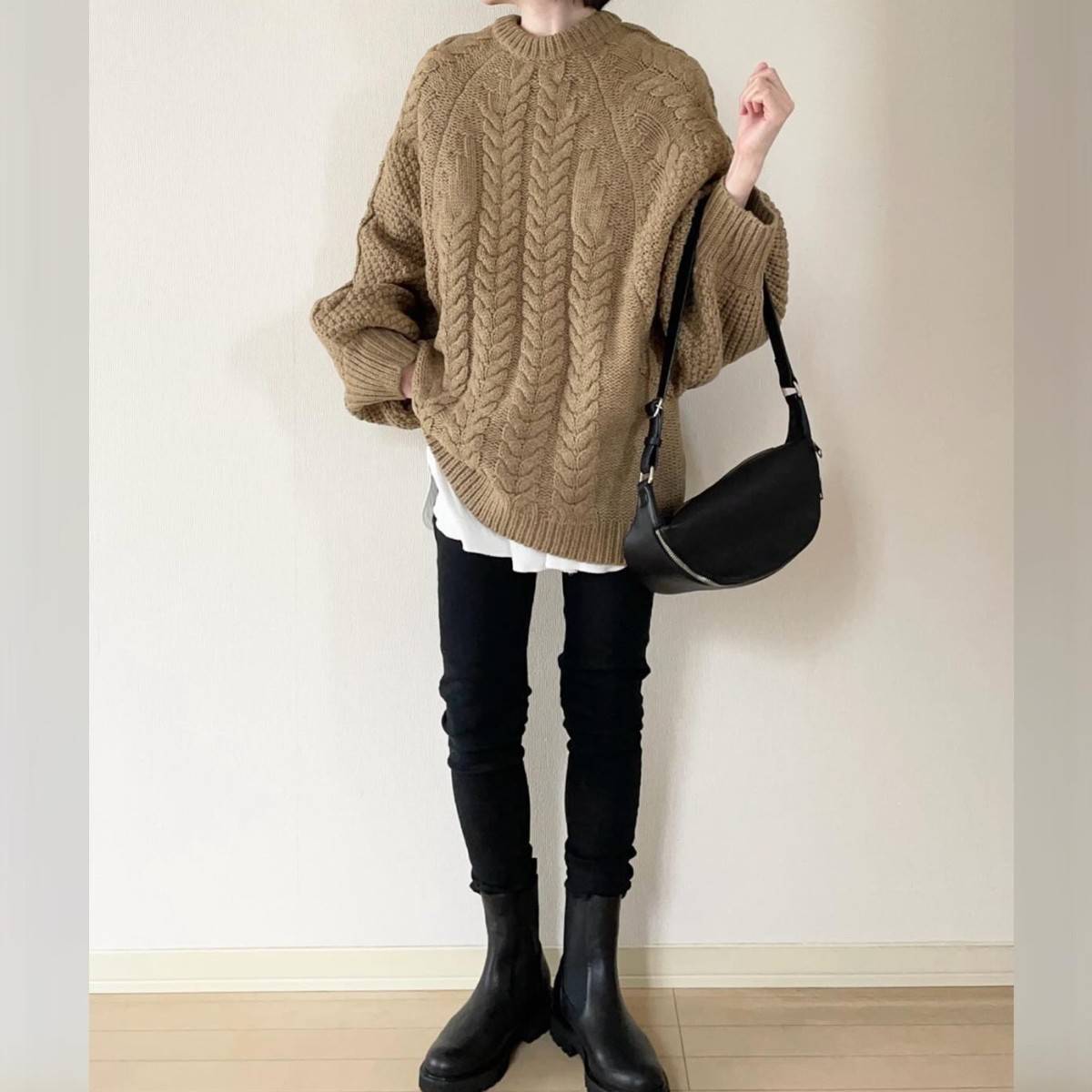 ブラウンのニットに黒パンツを合わせた女性
