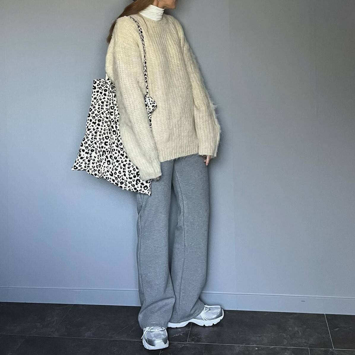 白ニットにグレーパンツを合わせた女性