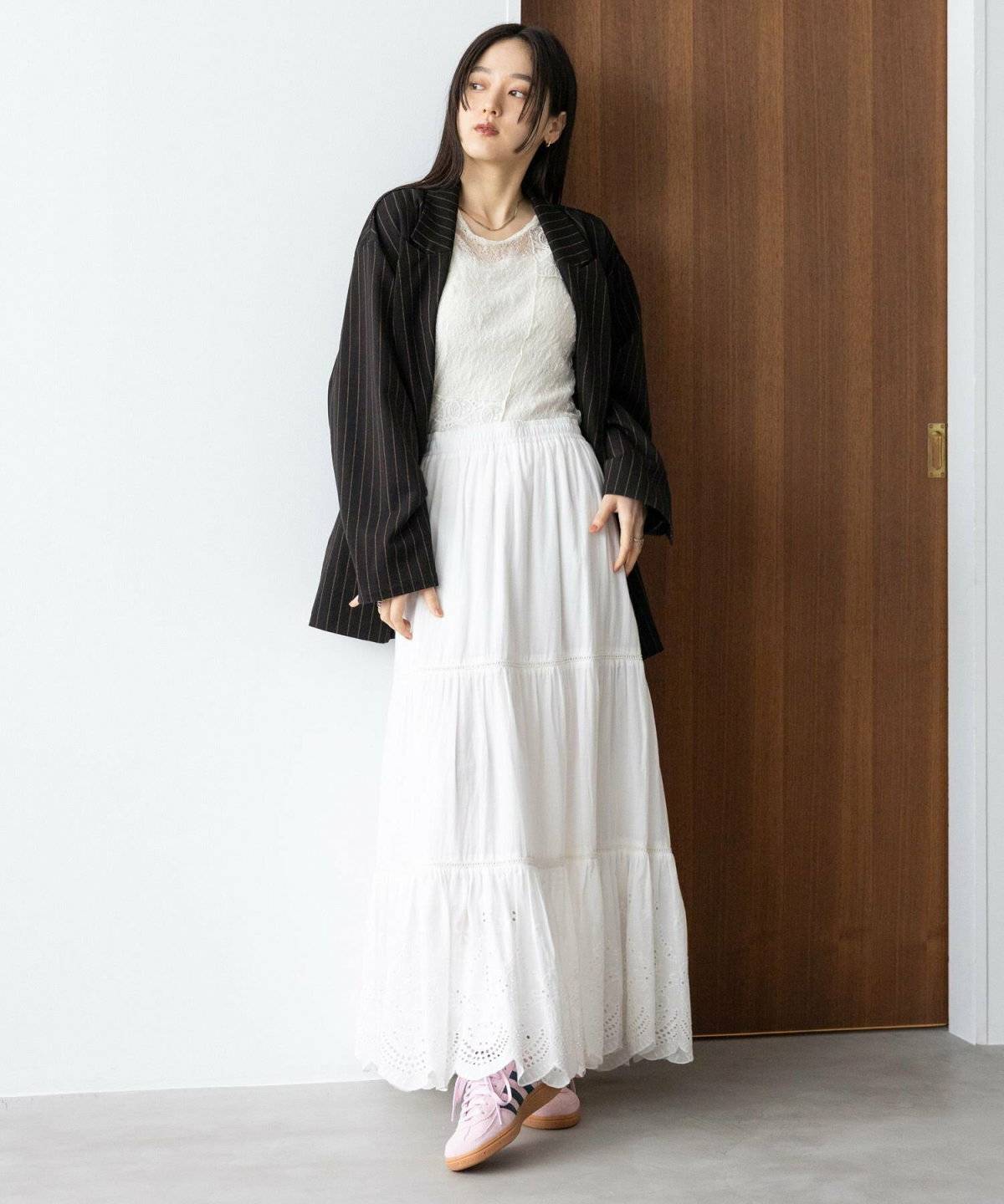 レーススカートを合わせてジャケットを肩掛けした女性