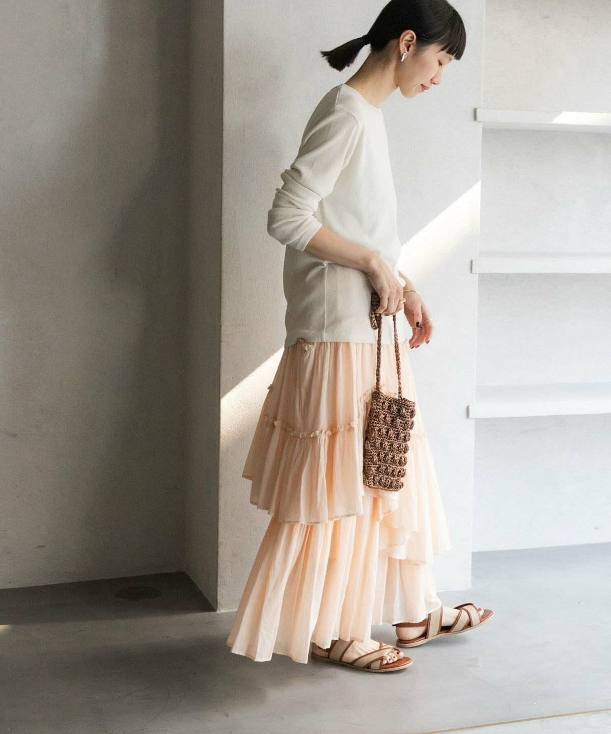 白ニットにピンクのスカートを合わせた女性