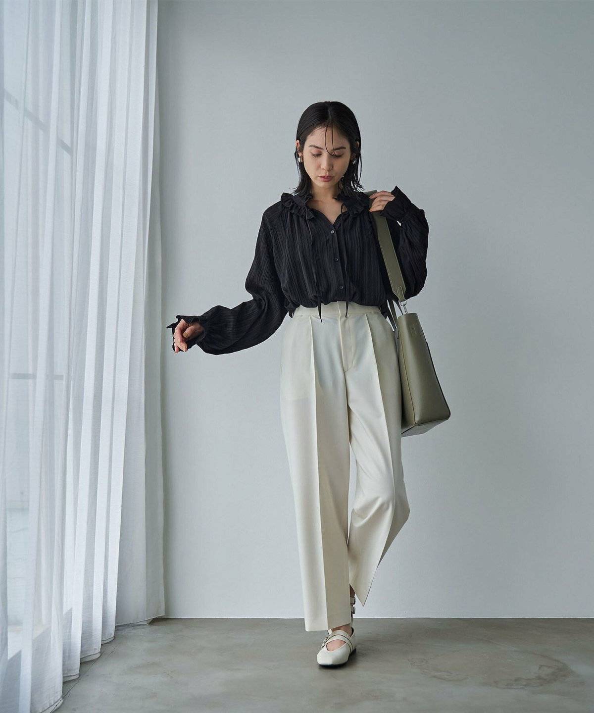 ブラウスに白パンツを合わせた女性