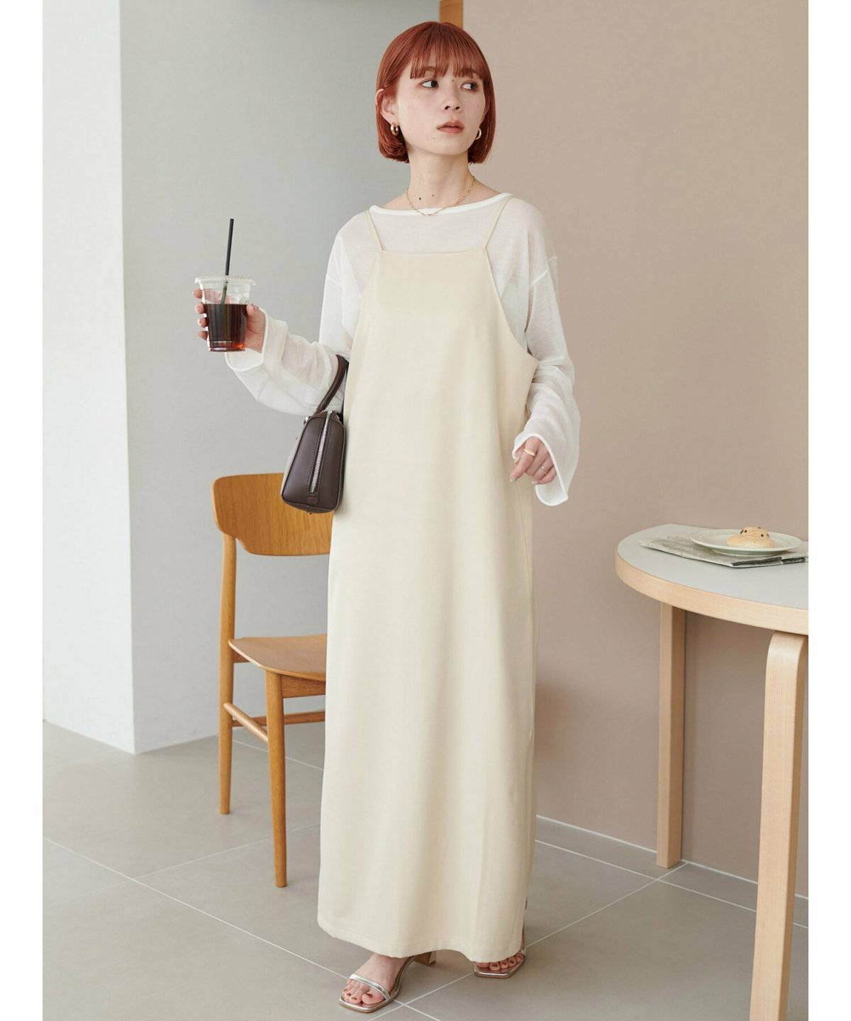 白トップスにベージュのワンピースを合わせた女性