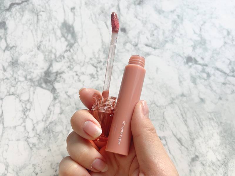 ロムアンドのグロスを手に持っている画像