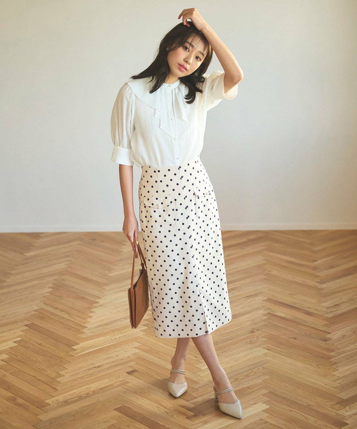 白ブラウスにベージュスカートを合わせた女性