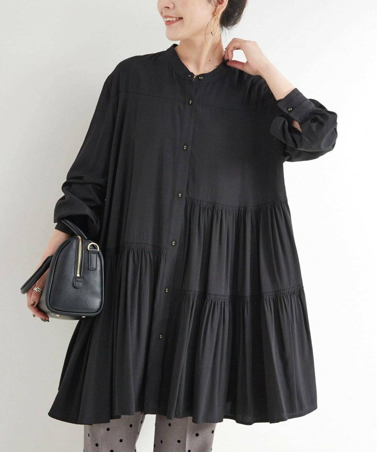 黒のニットワンピースにパンツを合わせた女性