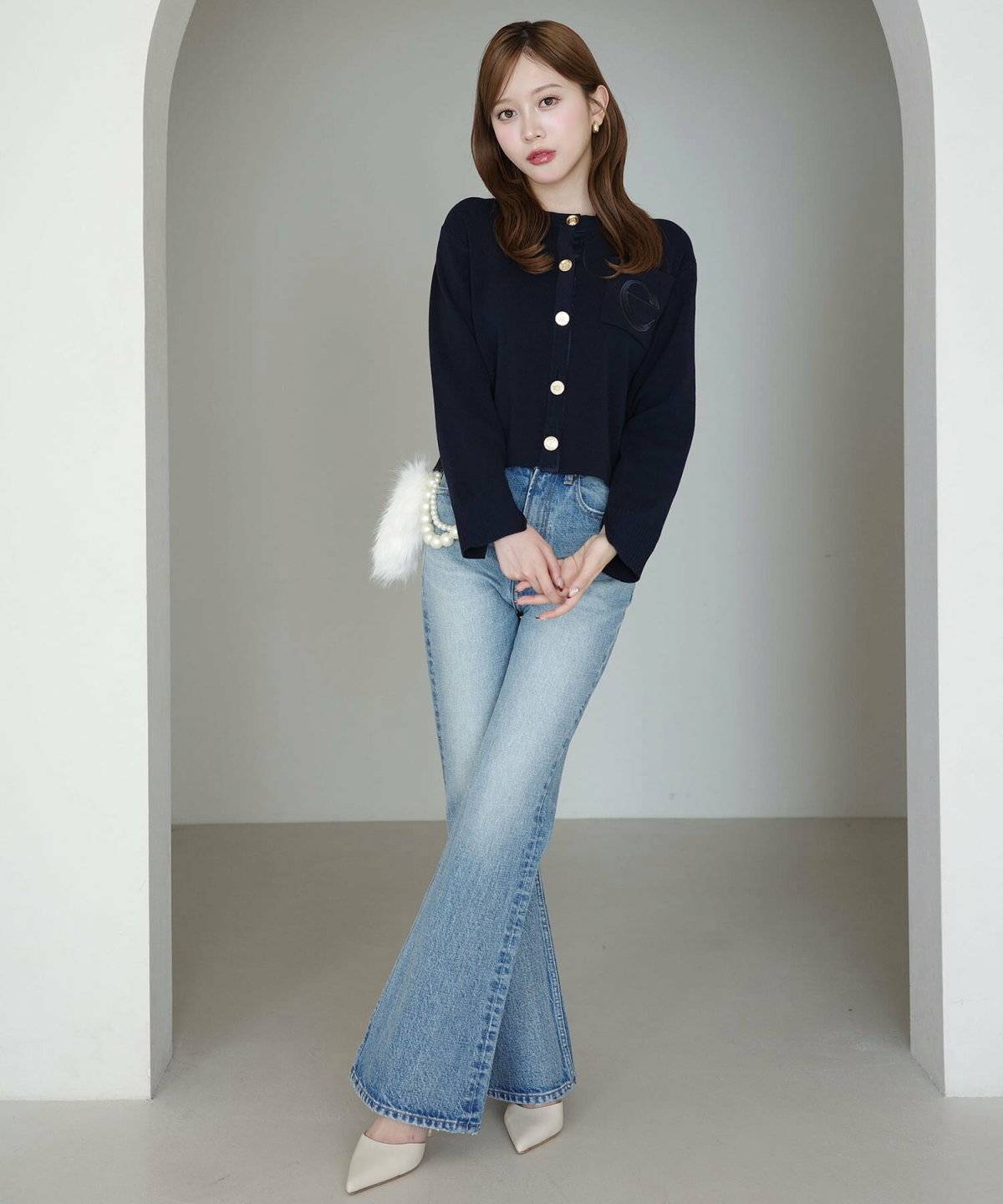 ネイビーのカーディガンにデニムを合わせた女性