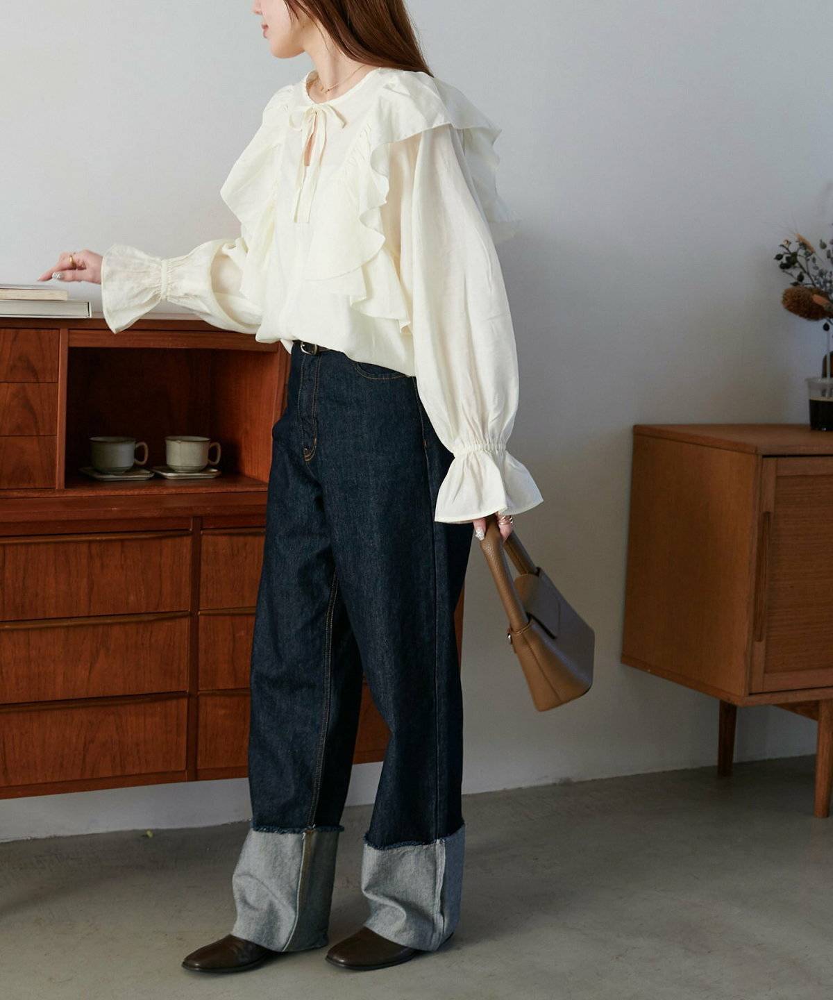 白ブラウスにデニムを合わせた女性