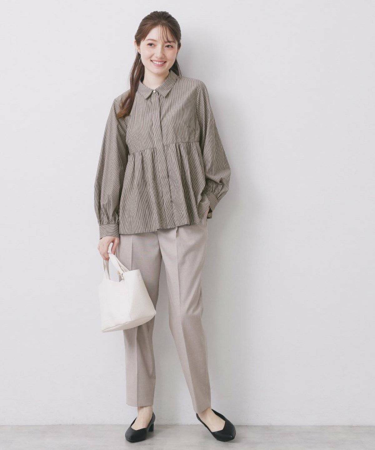 ストライプ柄のシャツにパンツを合わせた女性