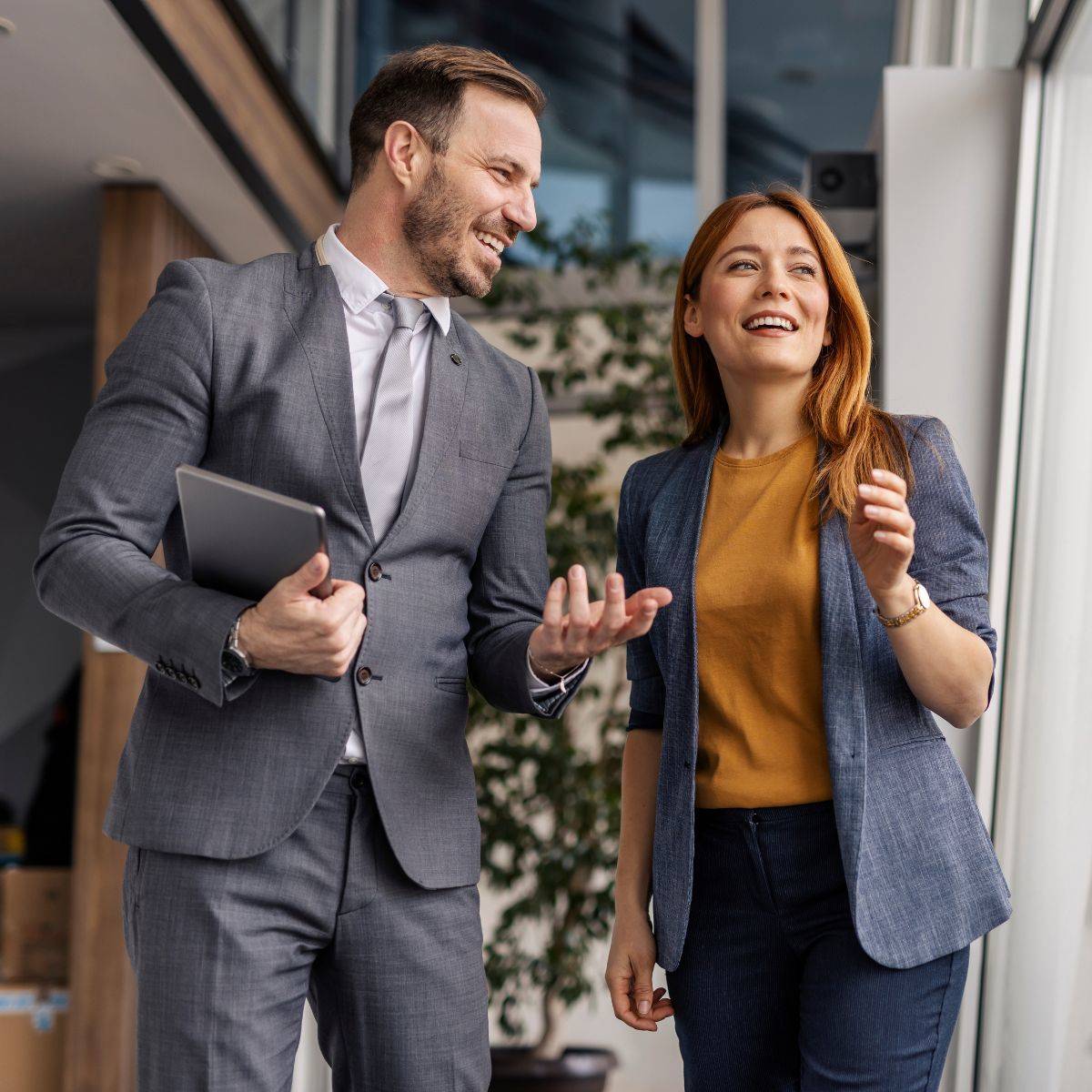 同僚の女性と立ちながら話す男性