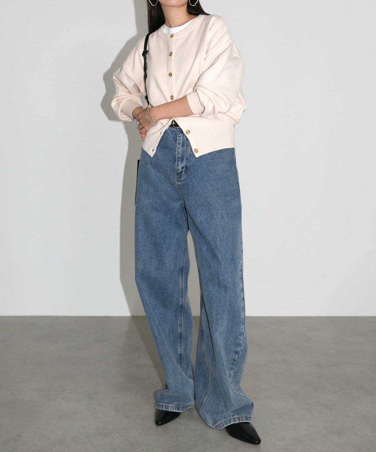 白カーディガンにデニムを合わせた女性