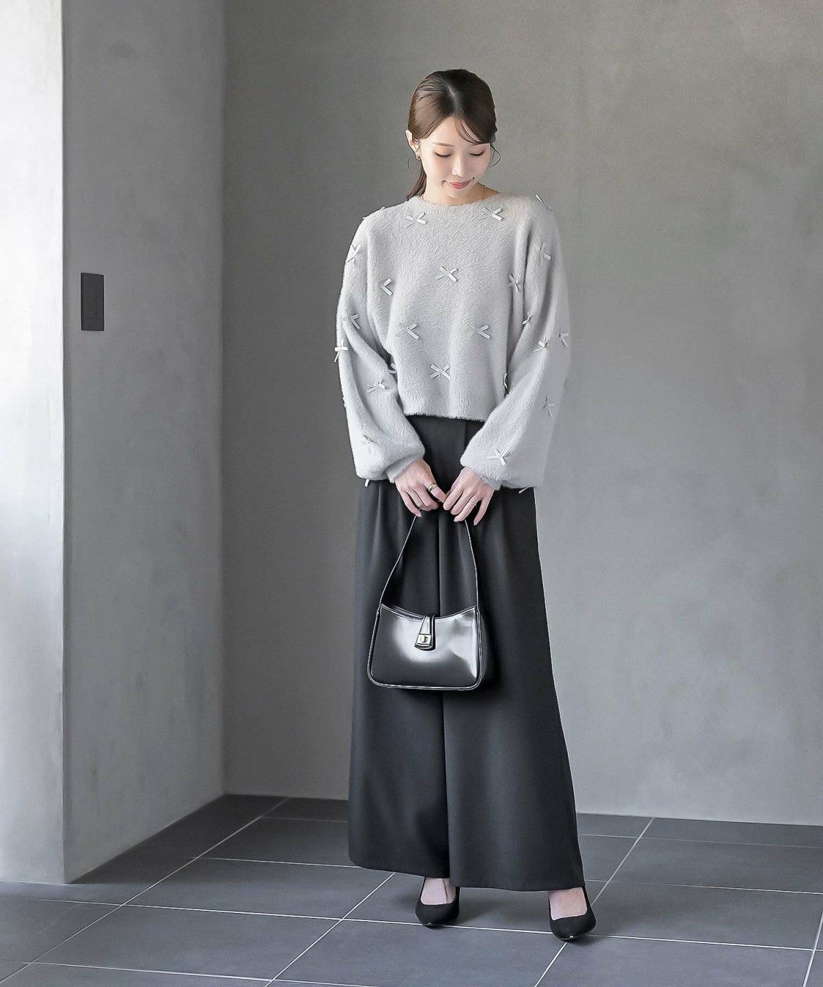 グレーのニットにデニムスカートを合わせた女性