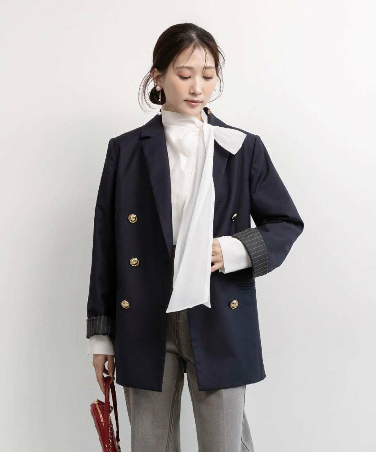 白シャツにデニムを合わせてネイビーのジャケットを羽織った女性