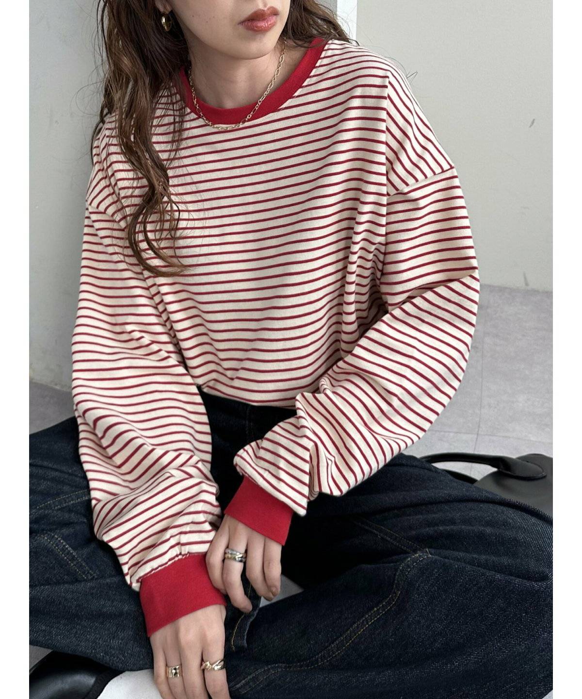 ボーダー柄トップスに黒パンツを合わせた女性