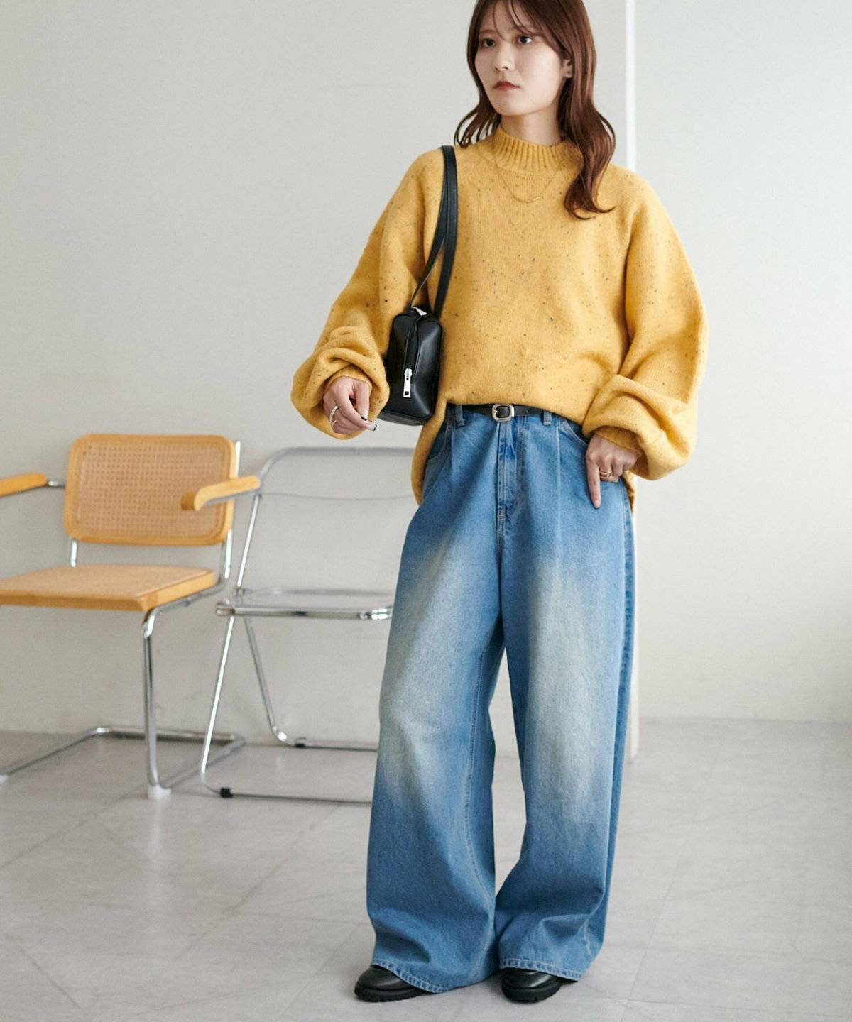 イエローのニットにデニムを合わせた女性