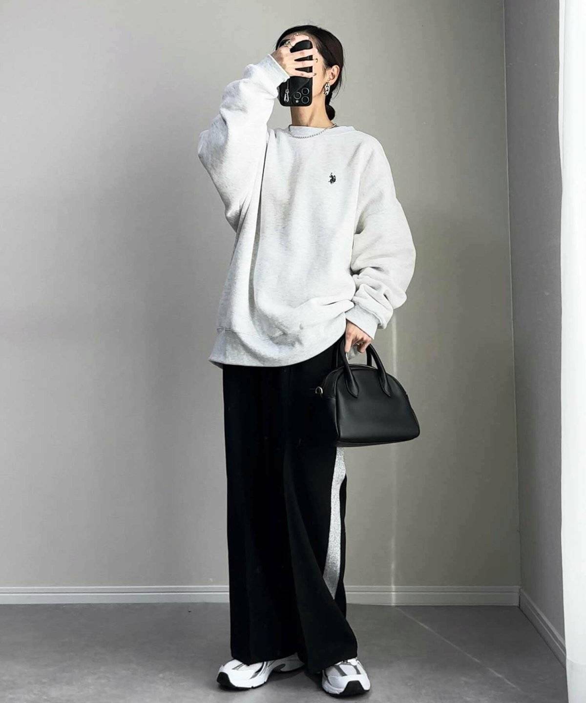 グレーのスウェットに黒パンツを合わせた女性