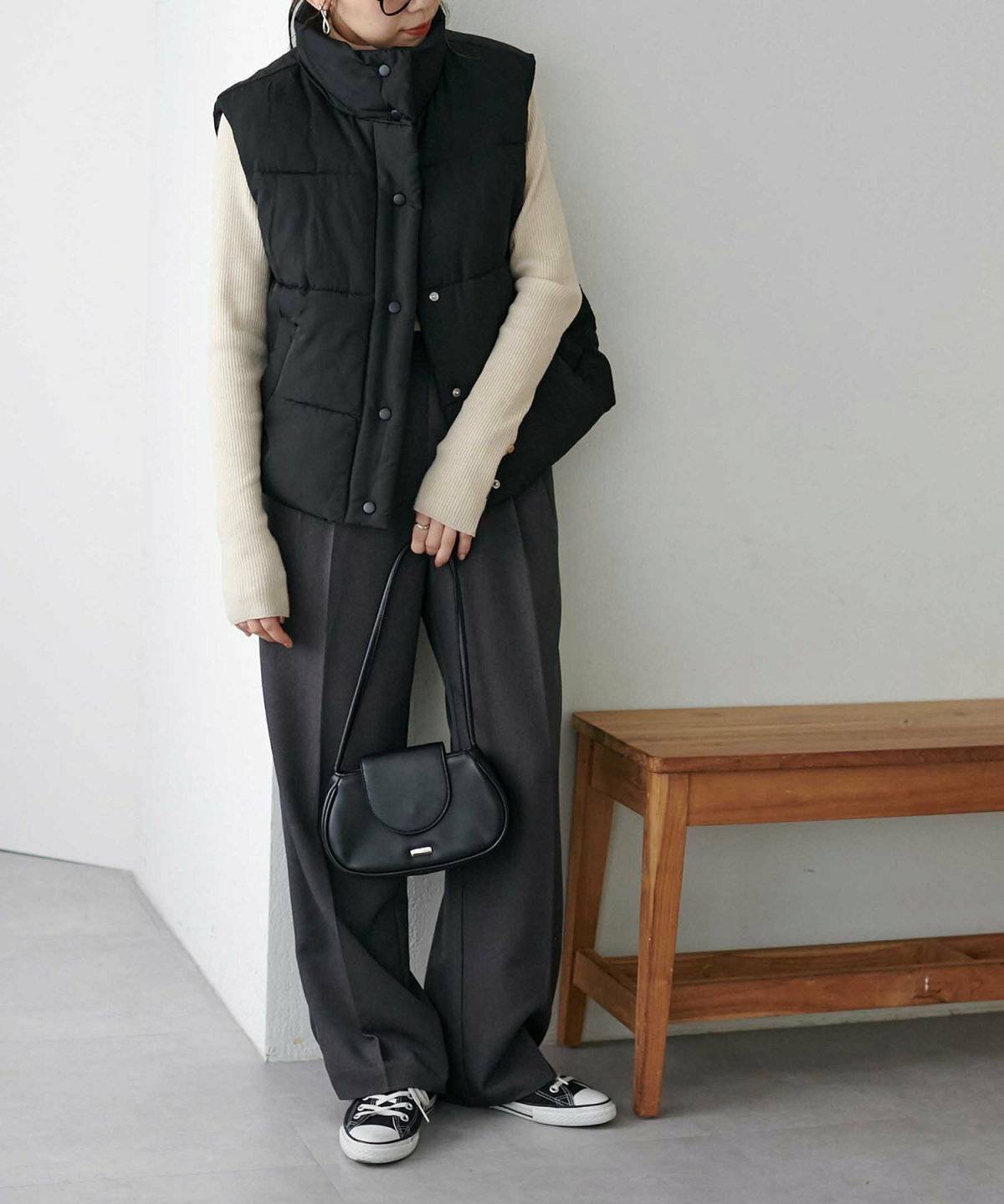 黒ベストを重ねた女性