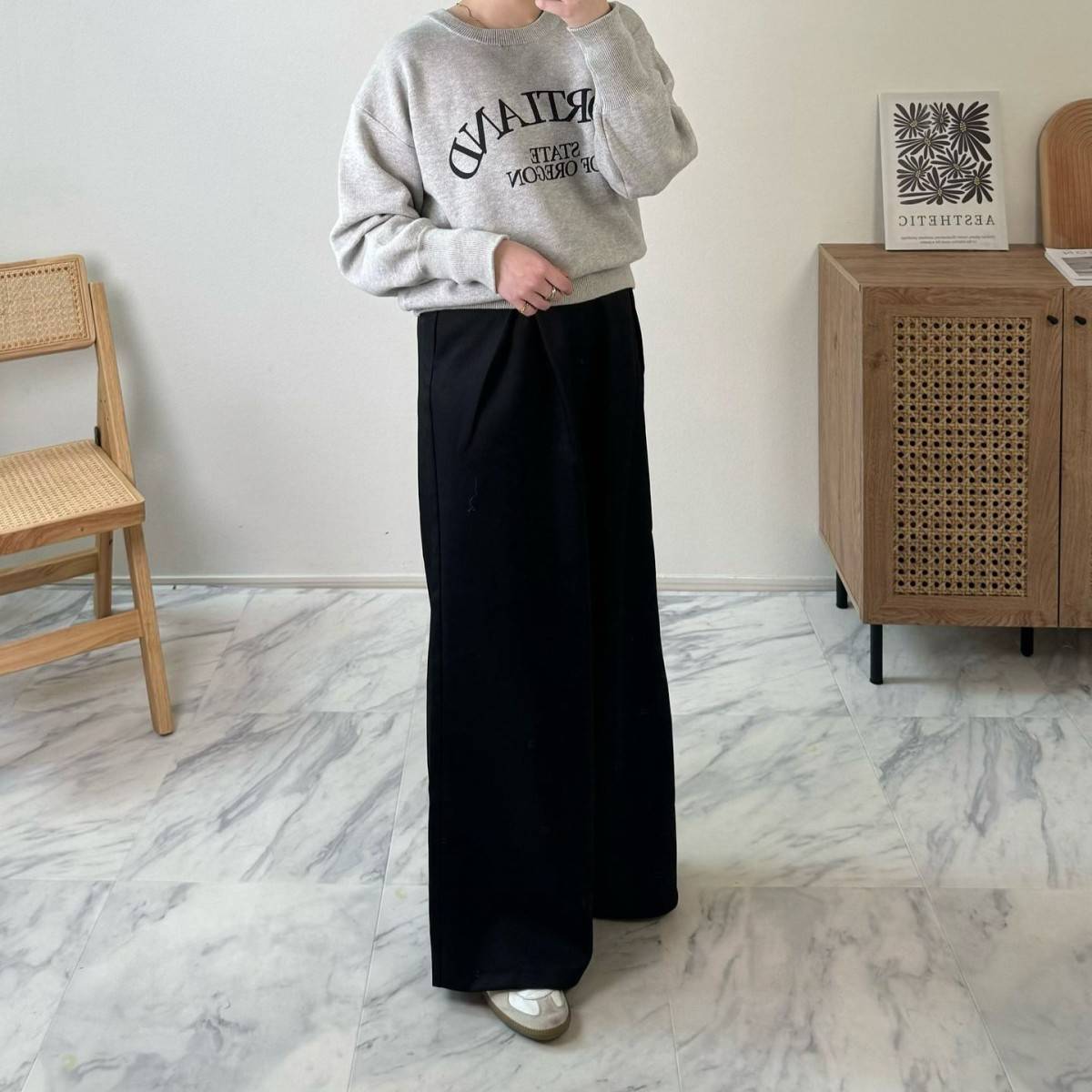 グレーのスウェットに黒パンツを合わせた女性