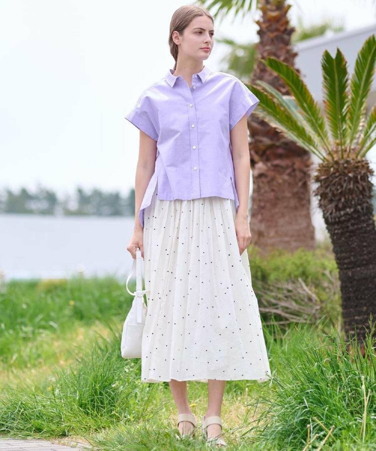 パープルのブラウスにスカートを合わせた女性