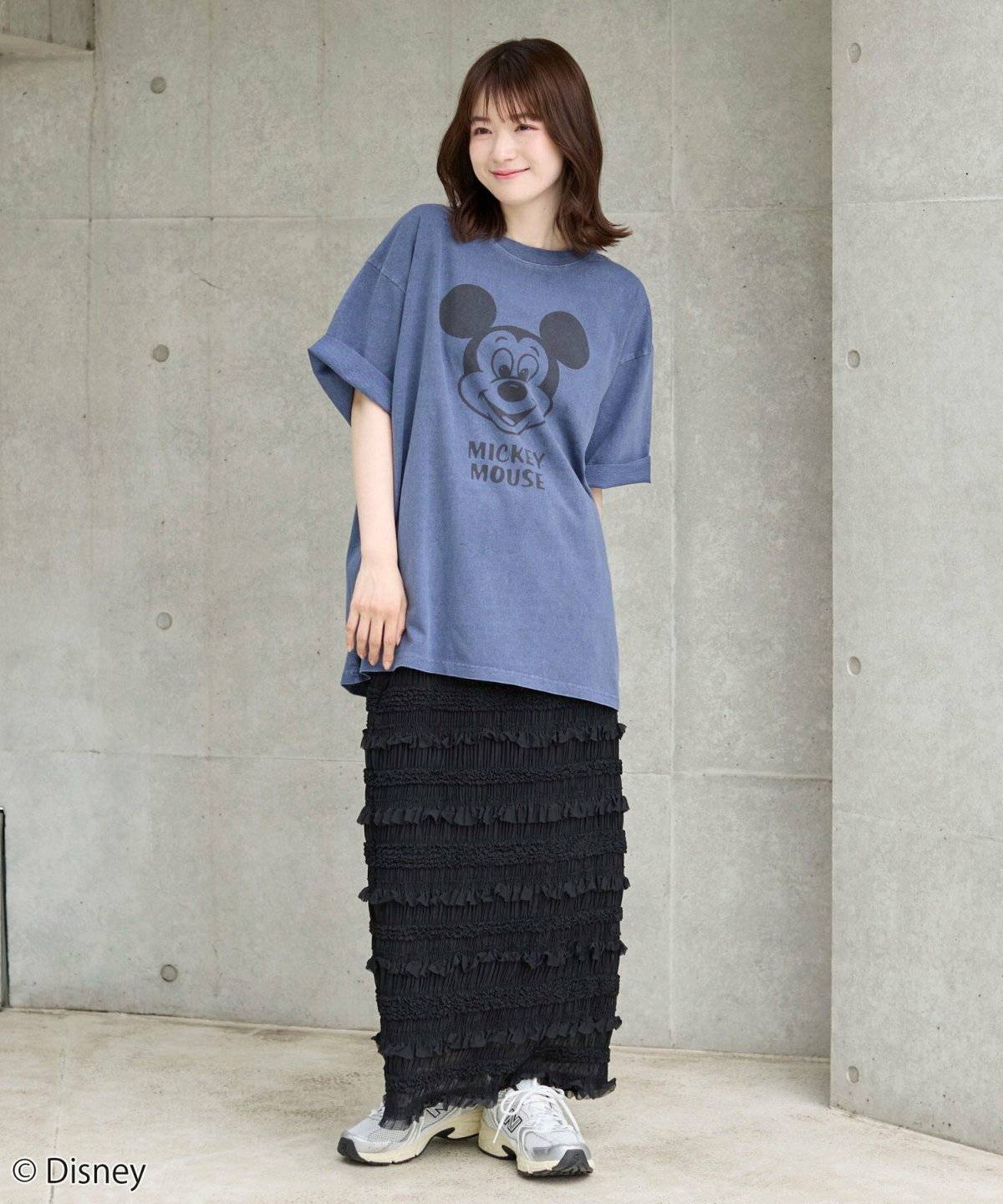 ブルーのTシャツにスカートを合わせた女性
