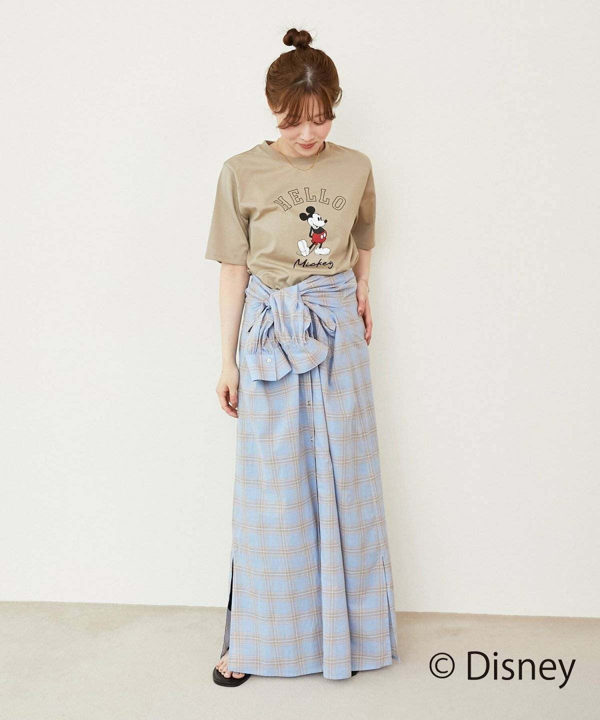 ベージュのTシャツにスカートを合わせた女性