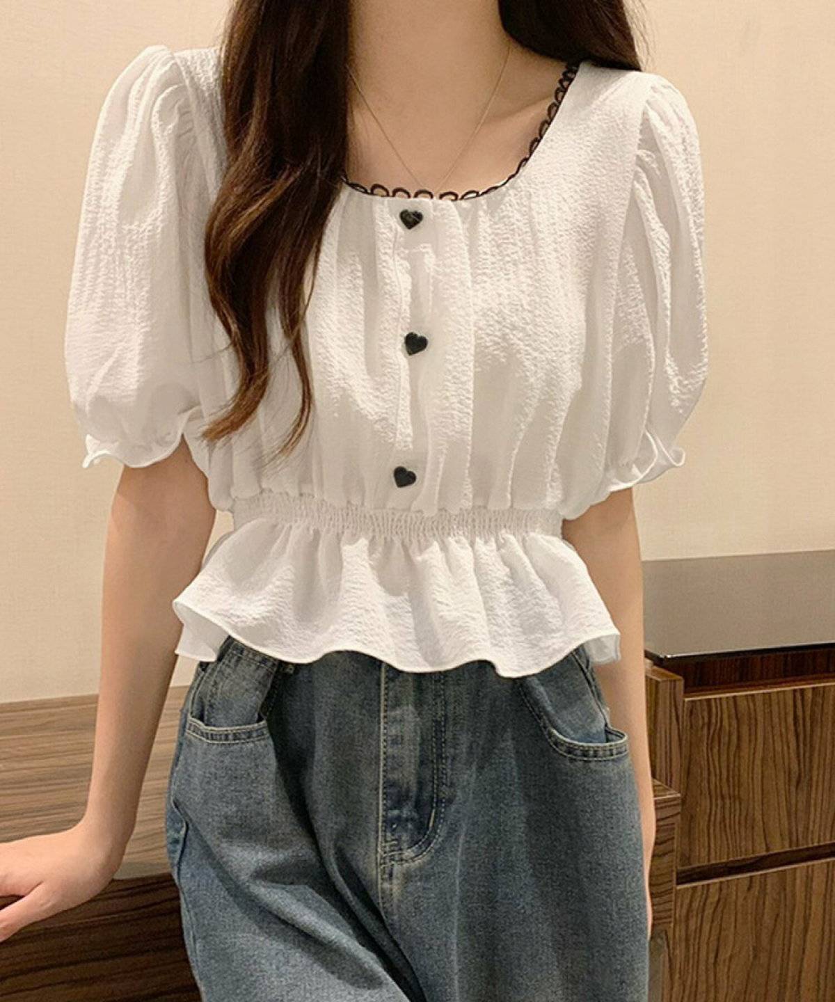 白のブラウスにデニムを合わせた女性