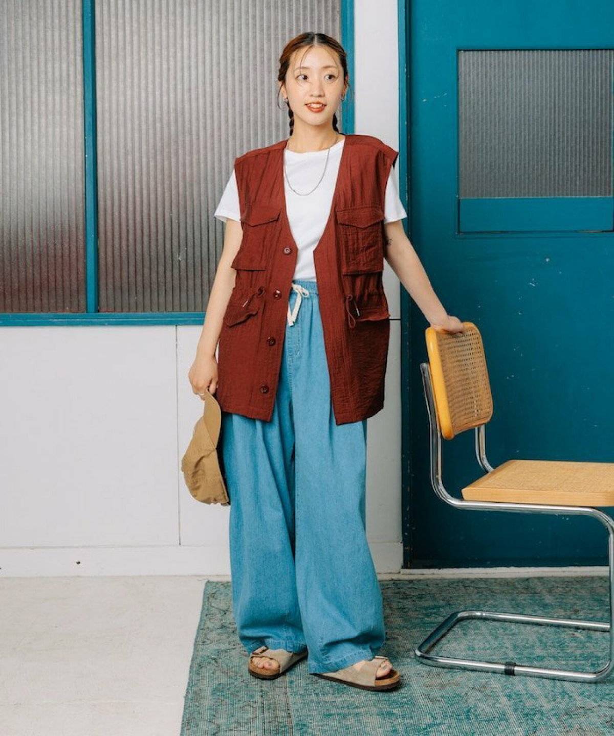 Tシャツにベストを重ねてデニムを合わせた女性