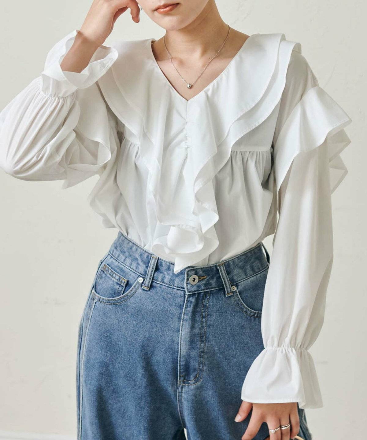 フリルブラウスにデニムを合わせた女性