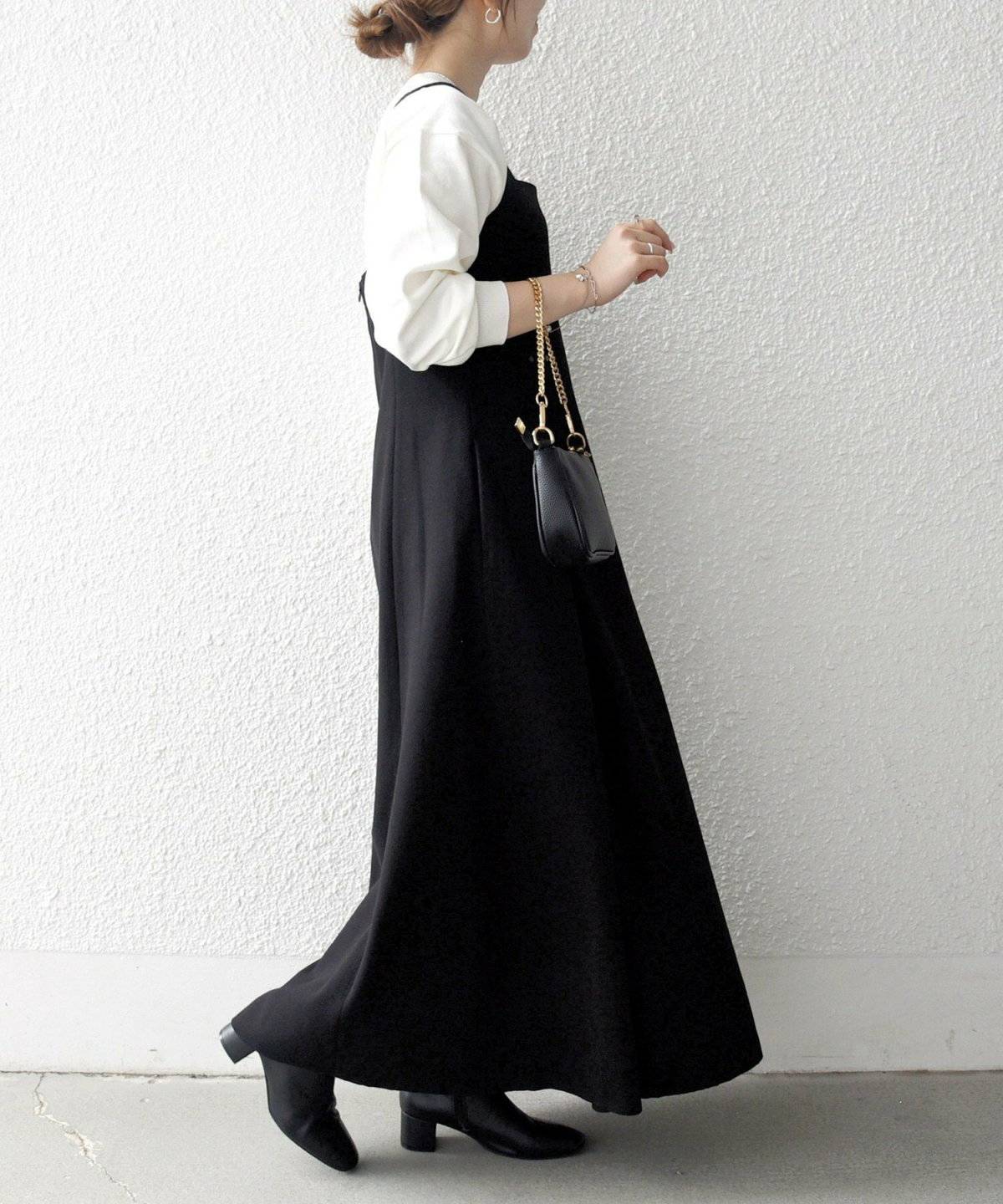 スウェットに黒ワンピースを重ねた女性