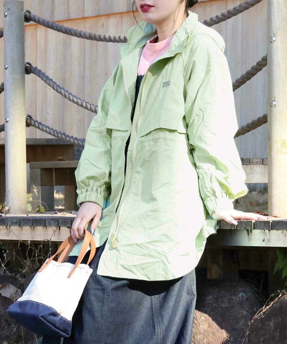 グリーンのアウターを羽織った女性