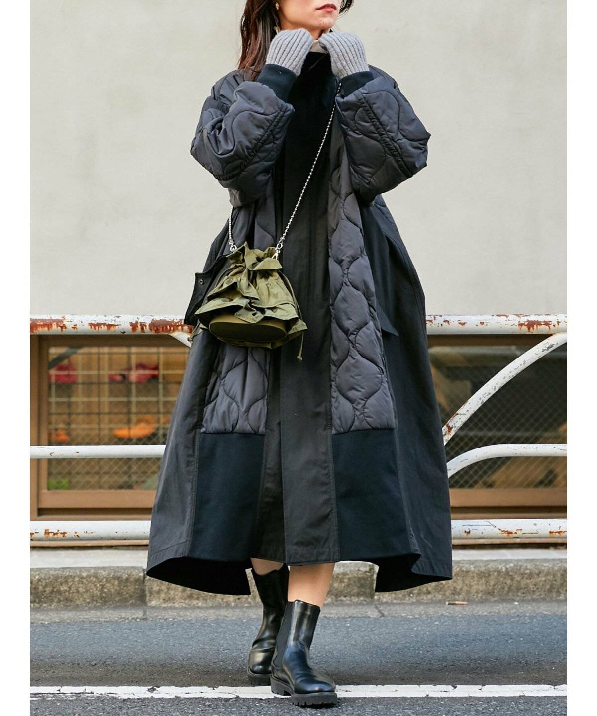 黒のキルティングコートを着た女性