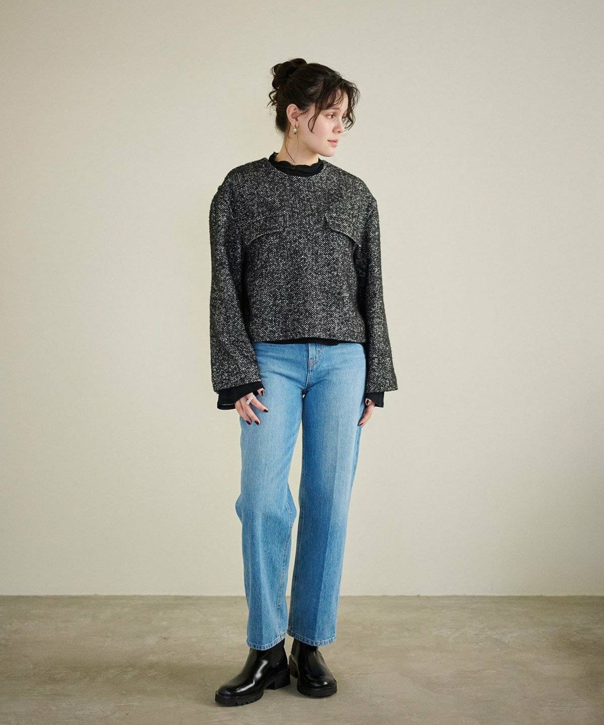 ツイードトップスにデニムを合わせた女性