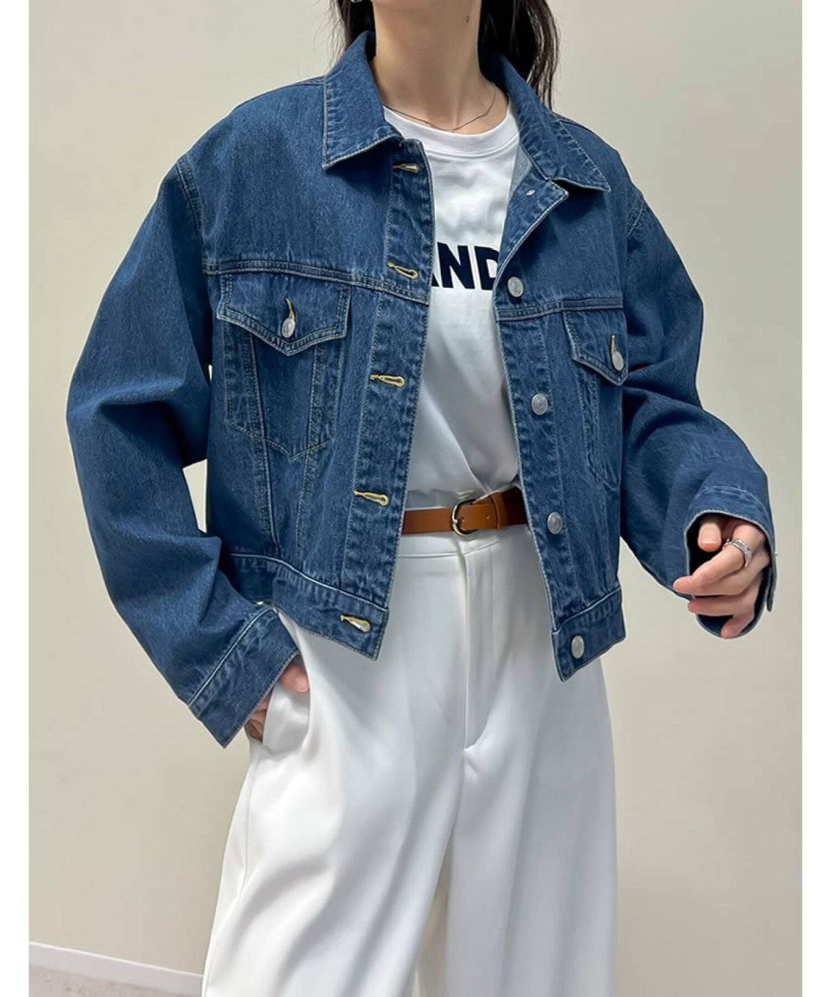 ホワイトコーデにデニムジャケットを羽織った女性