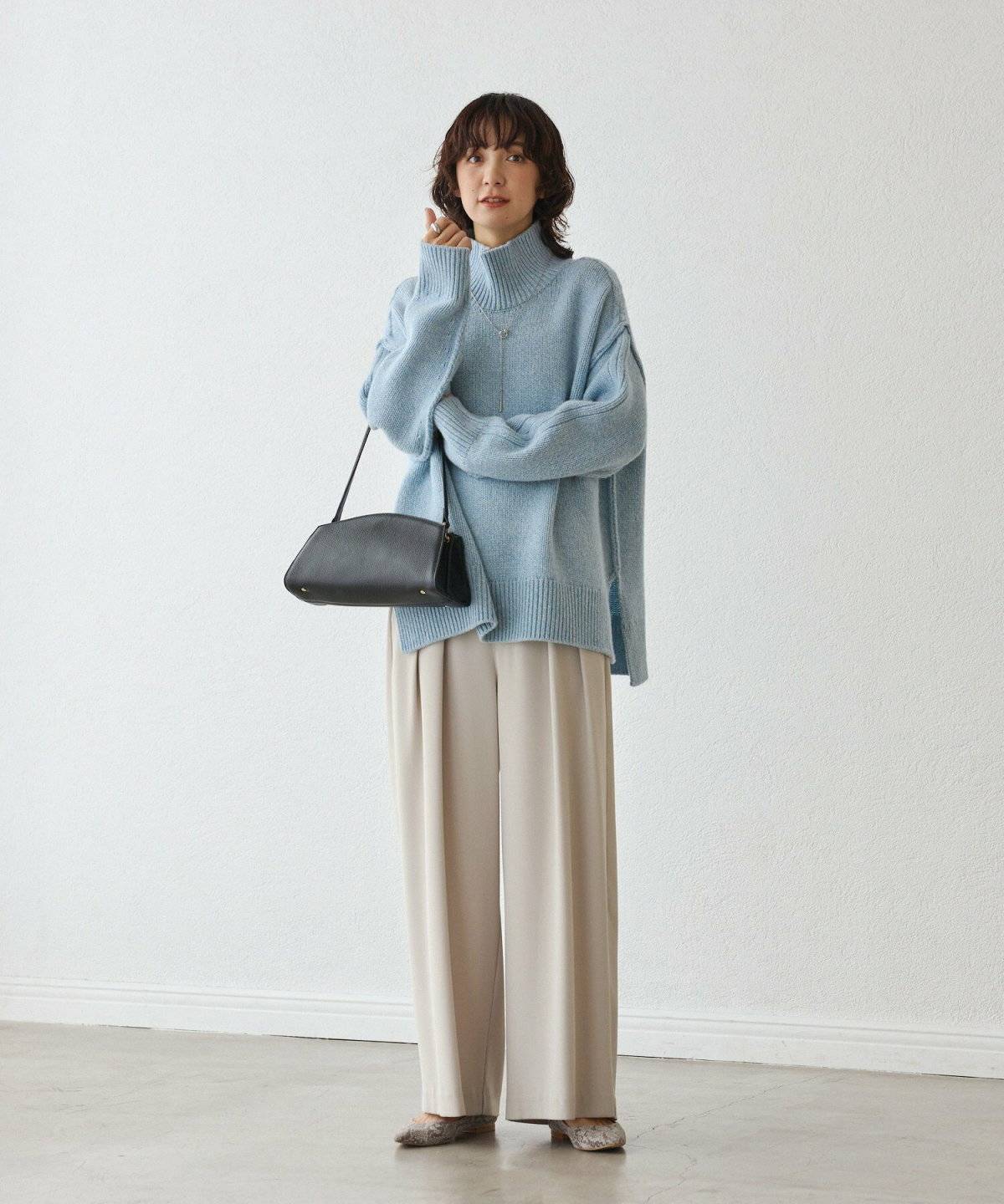 ブルーのニットにデニムを合わせた女性