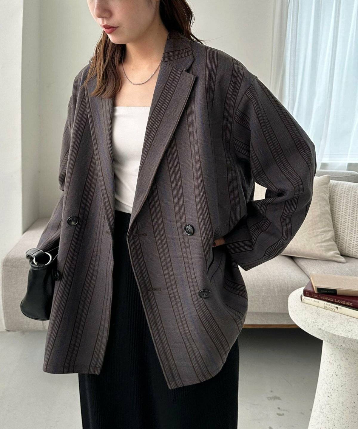 ブラックコーデにチェック柄ジャケットを羽織った女性