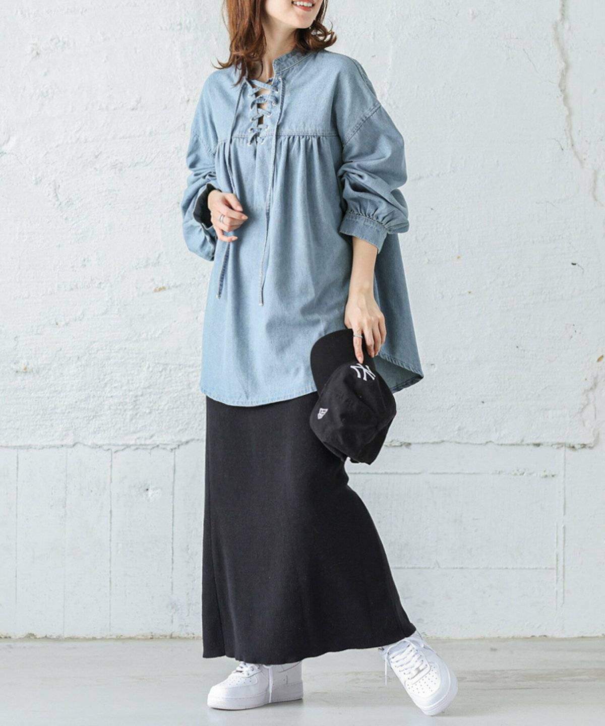 デニムブラウスにニットスカートを合わせた女性