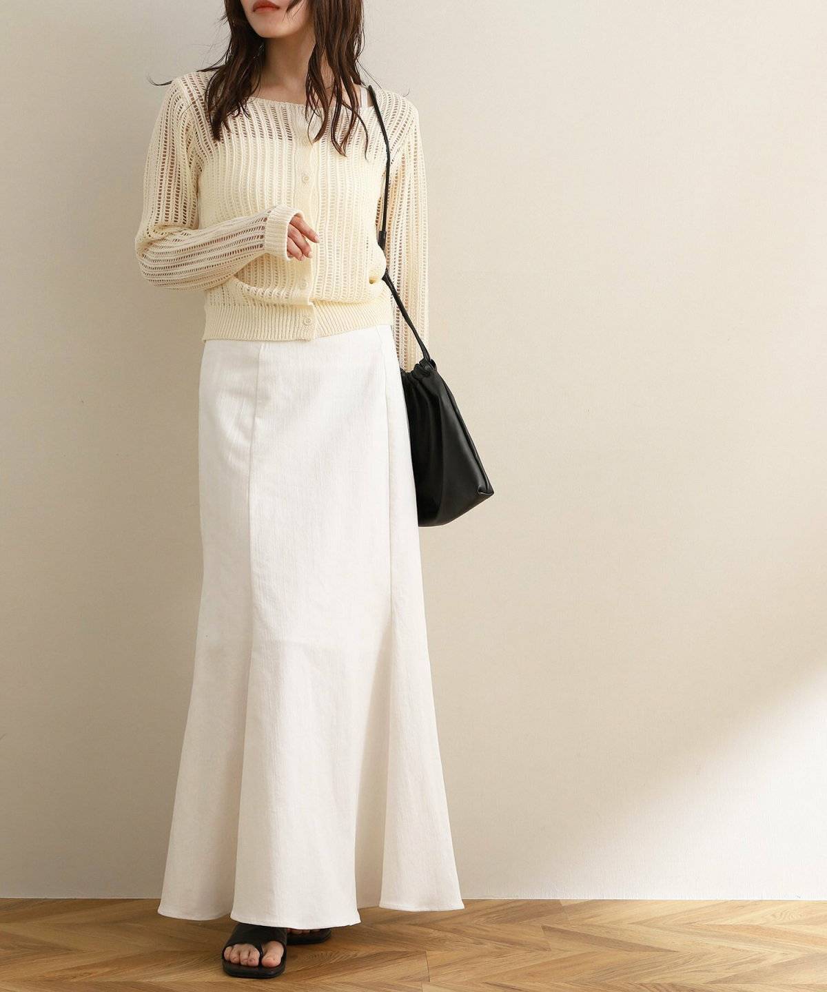 ワンピースに白ニットを重ねた女性