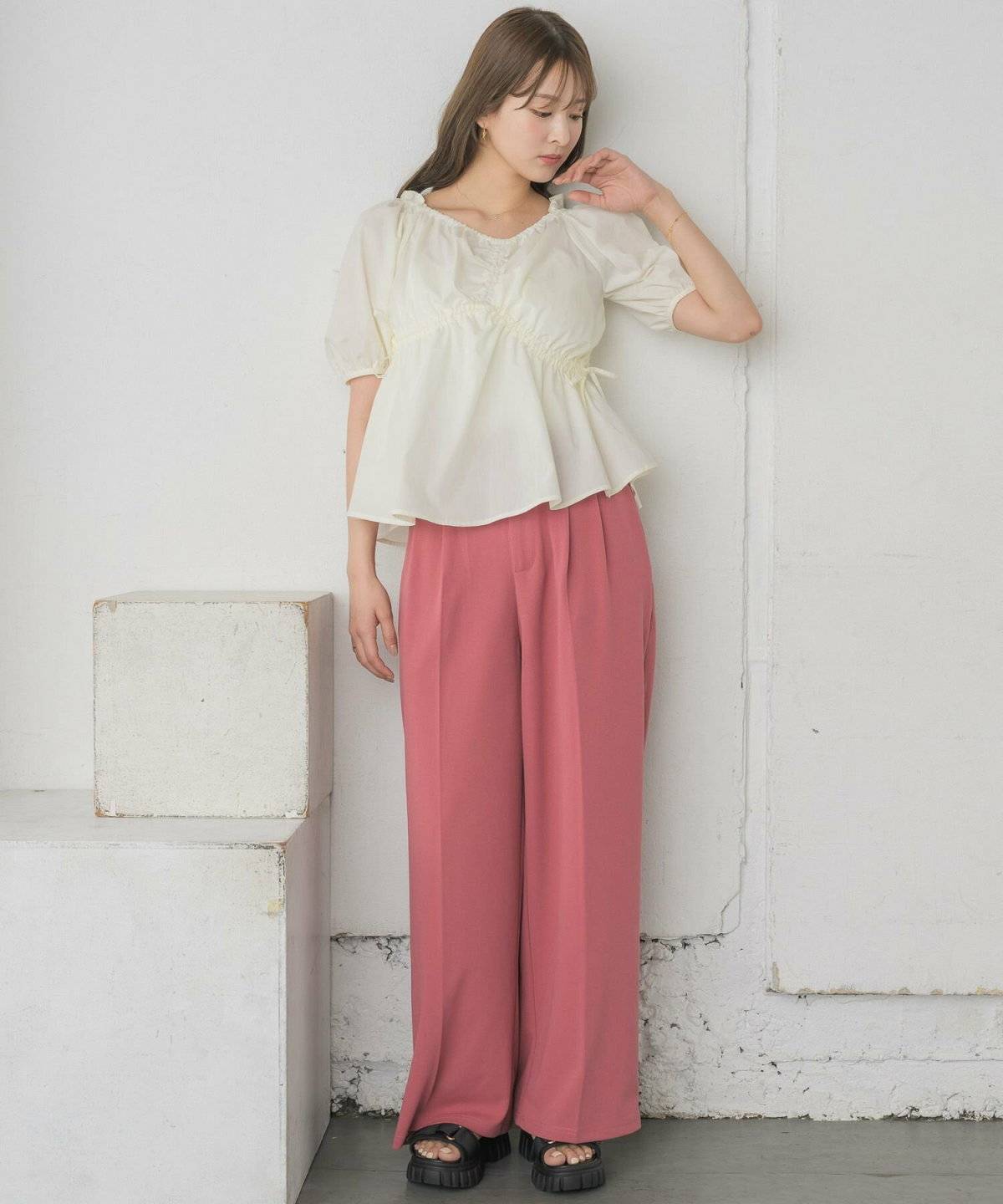 ホワイトブラウスにパンツを合わせた女性