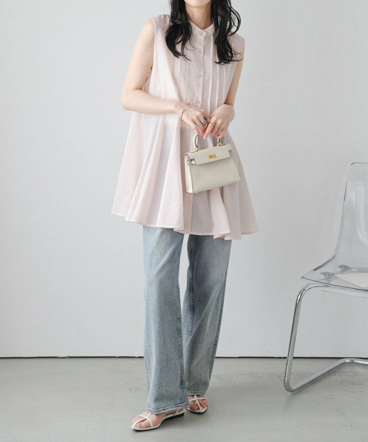 ピンクのブラウスにデニムを合わせた女性