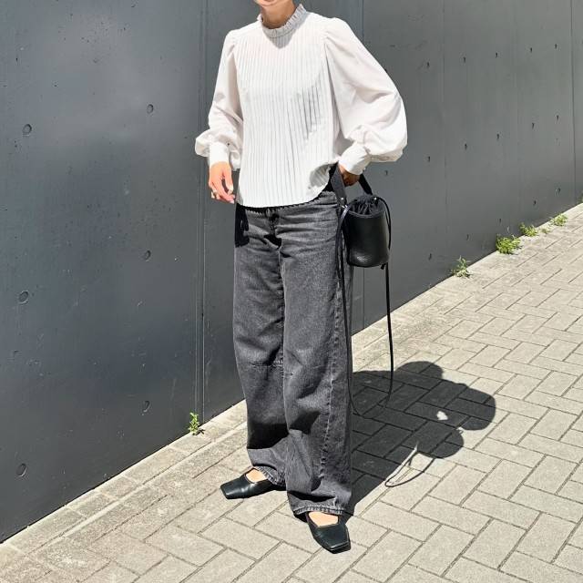 白ブラウスにデニムパンツを合わせた女性