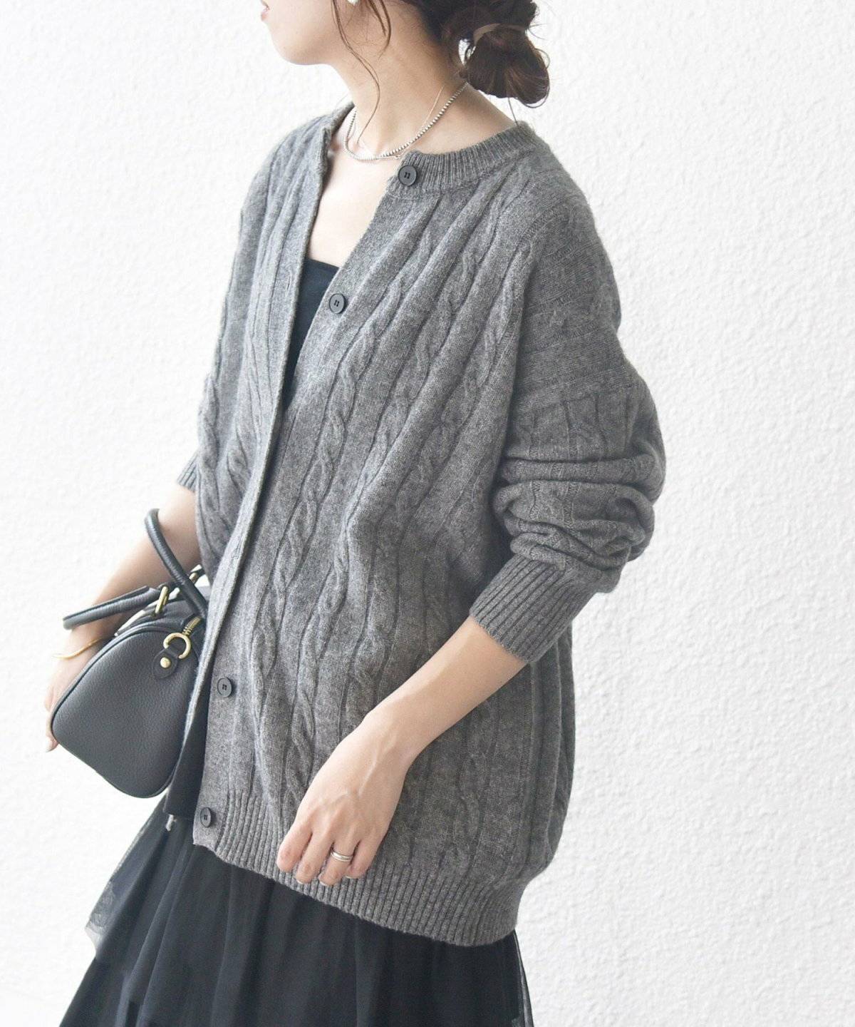 グレーのニットに黒スカートを合わせた女性