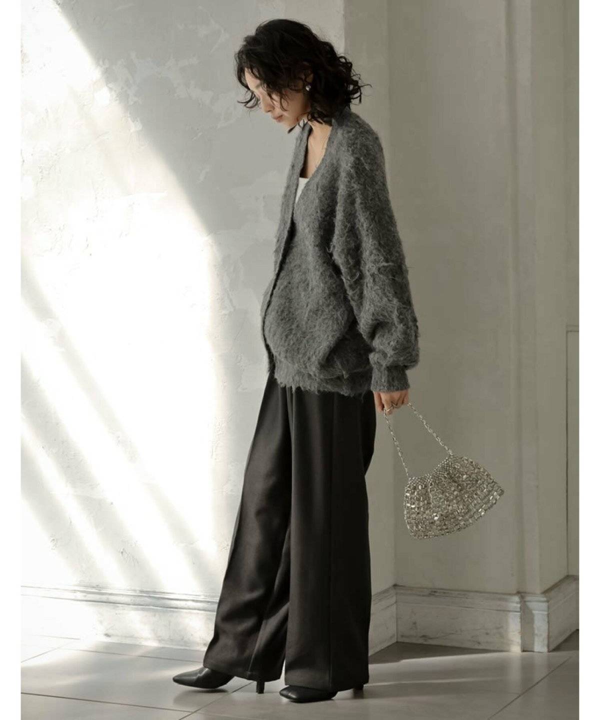 カーディガンに黒パンツを合わせた女性